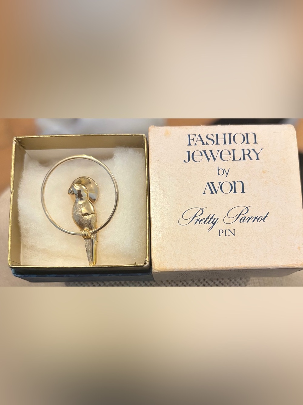 1980Avon Gold Tone Parrot Pin sitting on a round golden Hoop with original Box